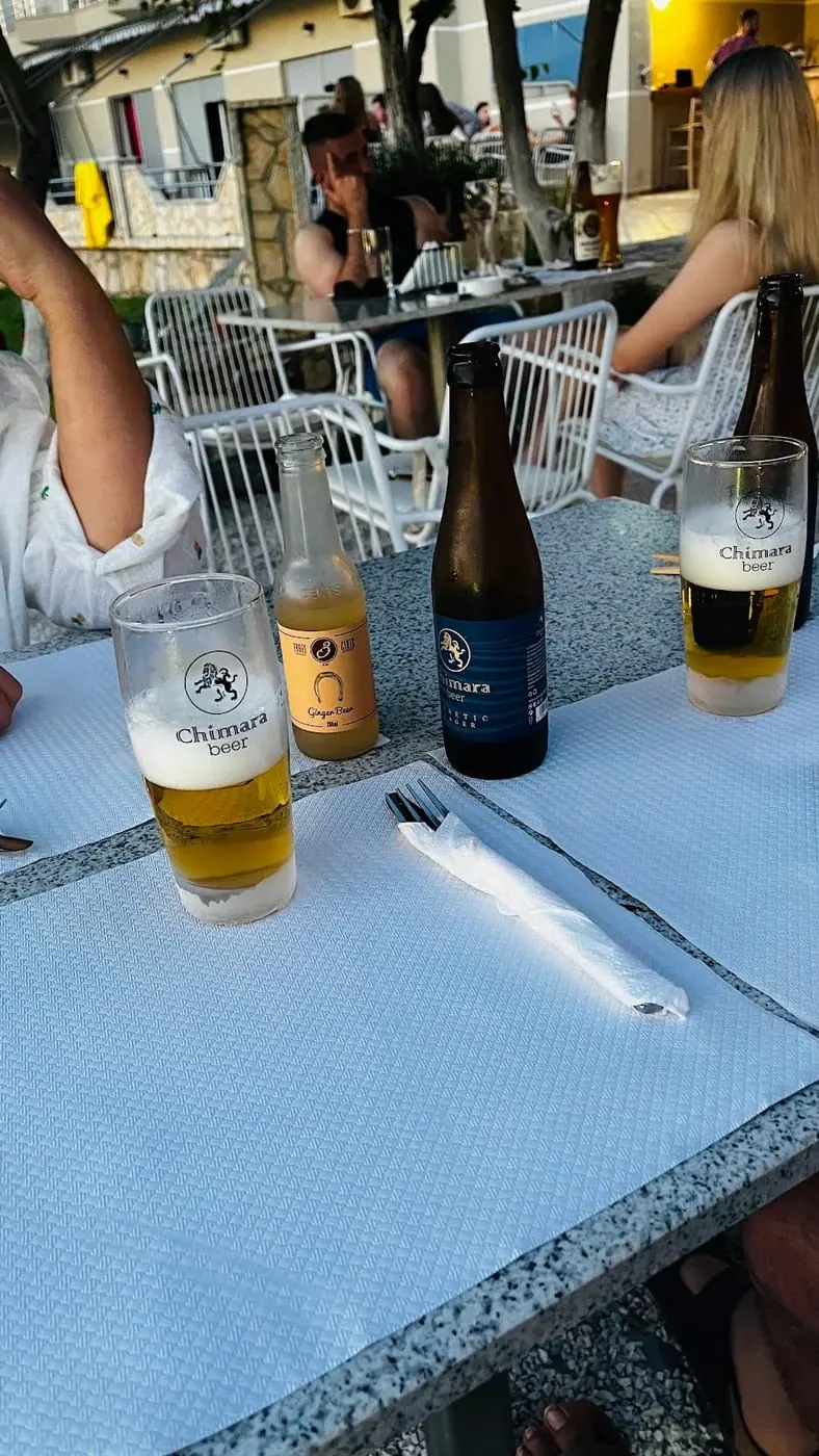 Bottles and glasses of Albanian beer on a table set with white linen